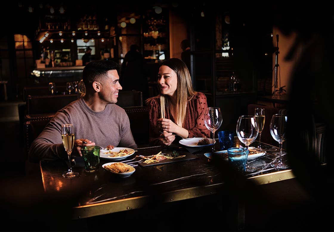 Couple enjoying drinks and food in a cosy pub atmosphere in Cornwall