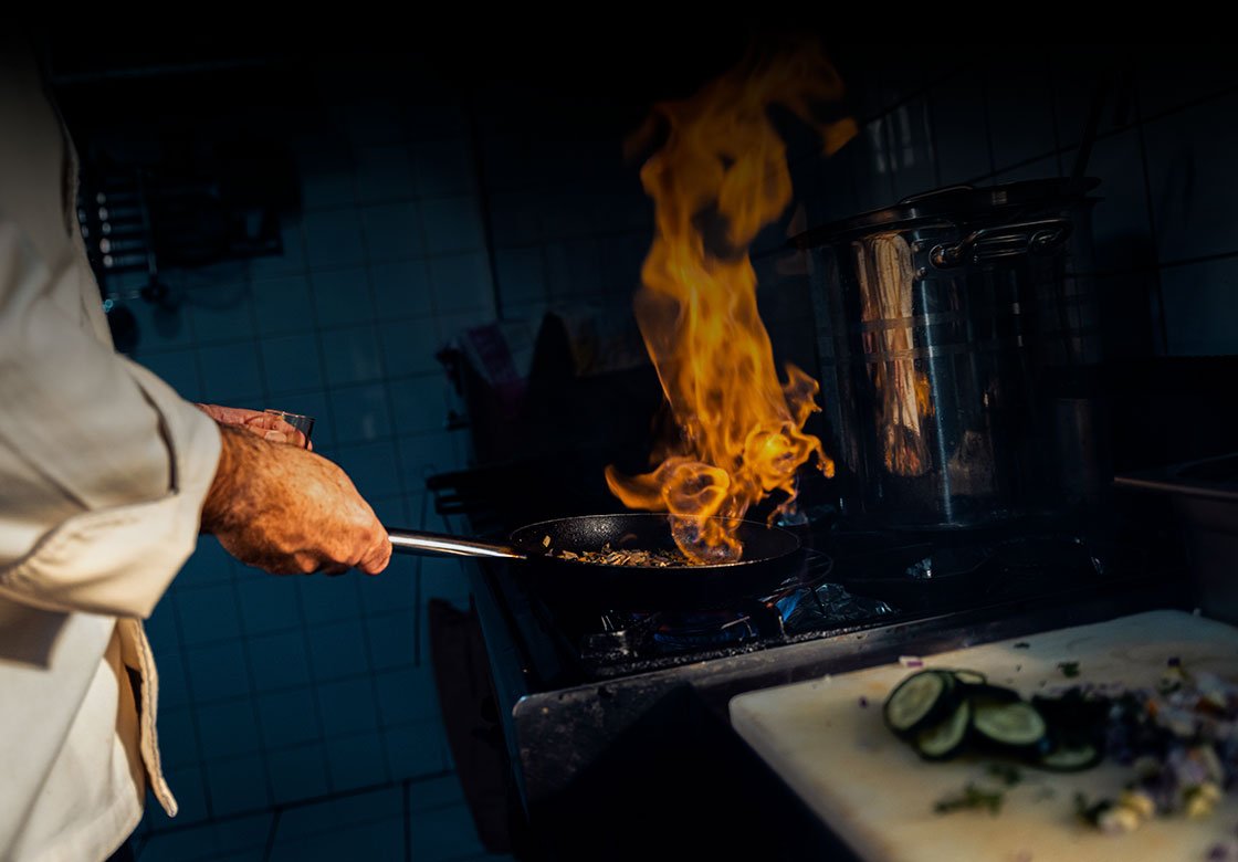 chef cooking over open fire in Cornwall kitchen, local ingredients, bucca mor restaurant concept