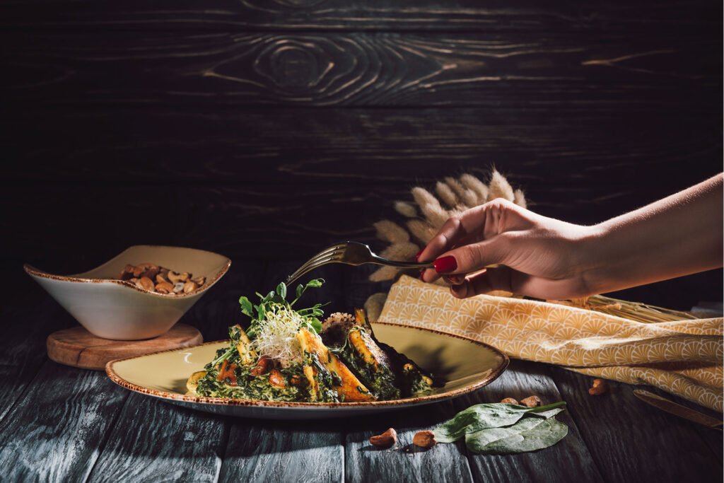 person sharing food at table, warm dining moment bucca mor restaurant cornwall