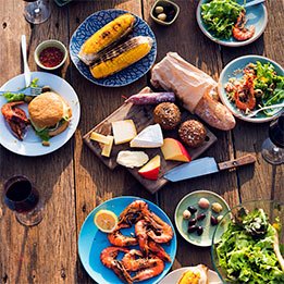 Shared dinner table with seafood bread and fresh dishes on wooden surface