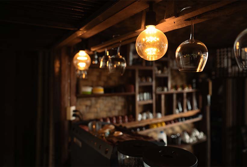 Warm lighting above a cosy bar area in an independent pub in Cornwall