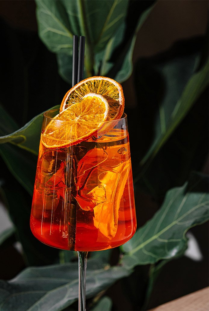 orange spritz cocktail with citrus garnish in a modern bar setting with natural light