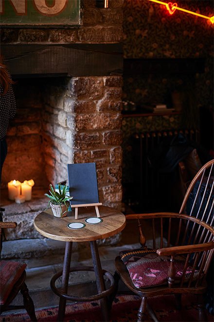 Traditional English pub interior with fireplace and warm lighting
